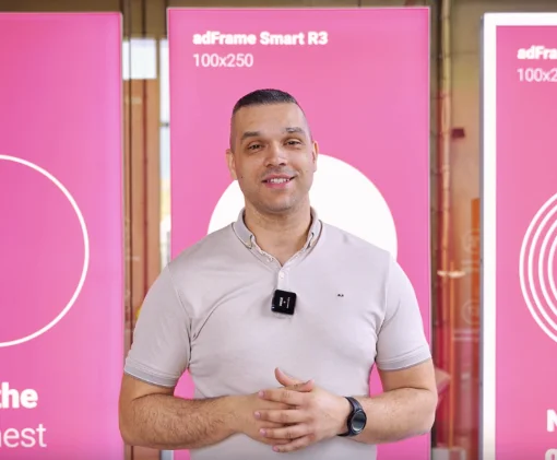 file-meta-description.mężczyznaprezentującykasetonyad-frame-smart-r3100x250natleróżowychpanelipodczasnagraniawshowroomielubnatargach.