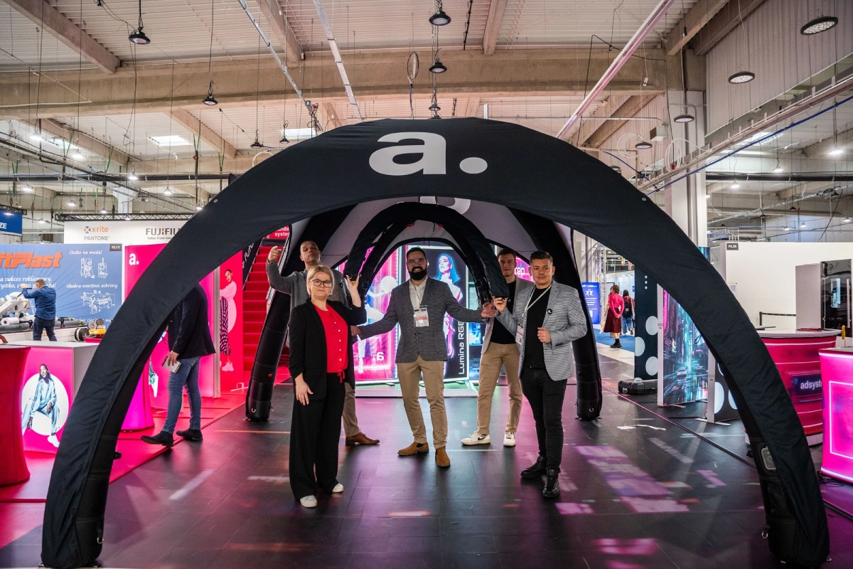 Equipo de adsystem en feria internacional, presentando estructuras hinchables y displays publicitarios para eventos y exposiciones.