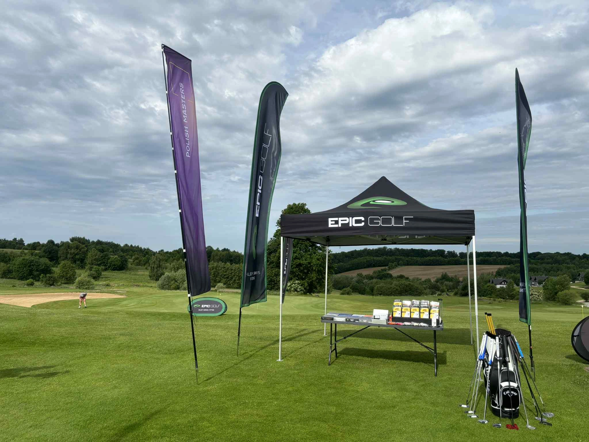 Namiot reklamowy i flagi ustawione na polu golfowym