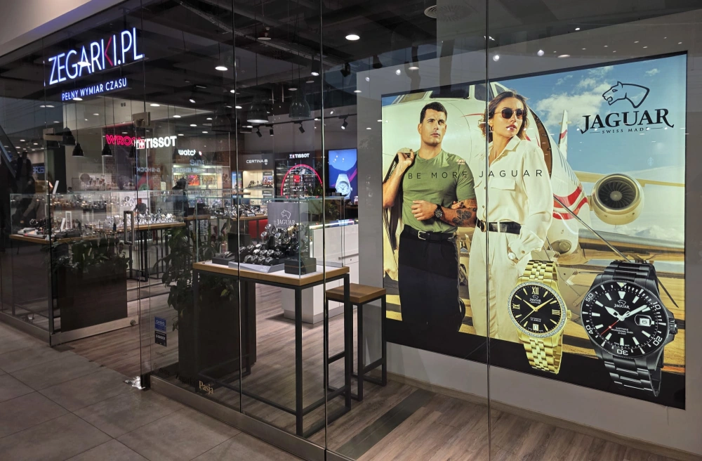 Kaseton reklamowy zawieszony w sklepie z zegarkami w centrum handlowym.