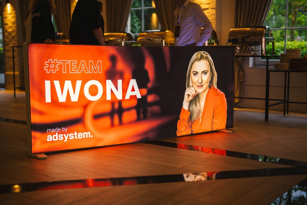 Podświetlany kaseton reklamowy podczas wieczornego wydarzenia branżowego w sali bankietowej