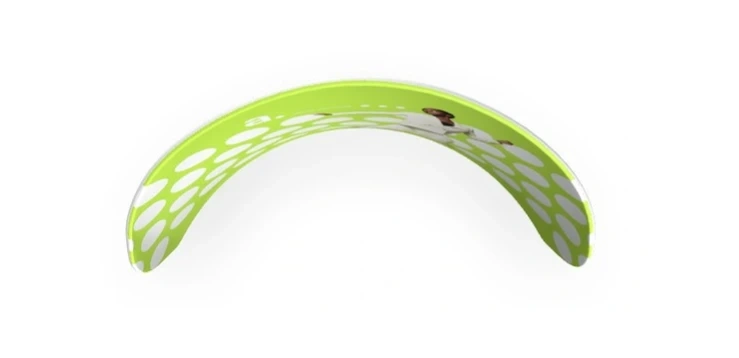 Widok z góry na łukową ściankę reklamową w neonowej zieleni, z białymi kropkami i grafiką kobiety w białym garniturze, rozciągającą się na wewnętrznej stronie konstrukcji.