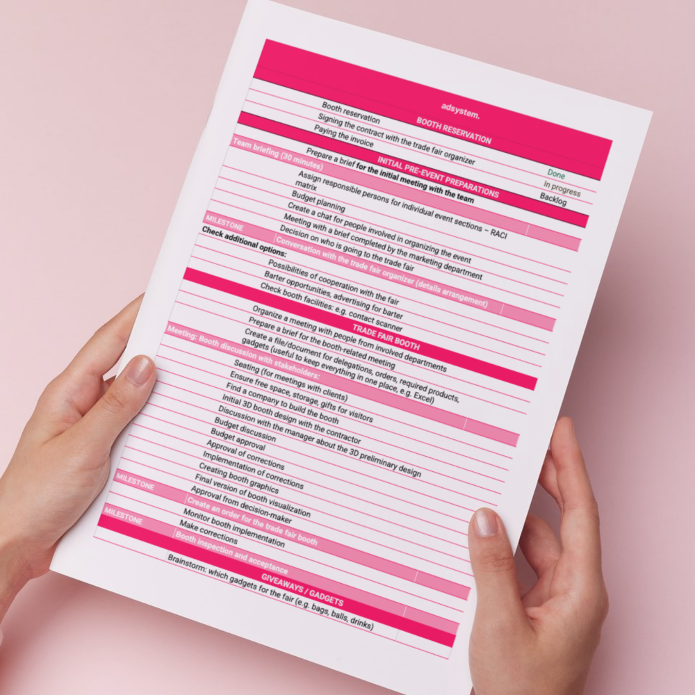 Checklista targowa z etapami przygotowań i organizacji stoiska, trzymana w dłoniach.
