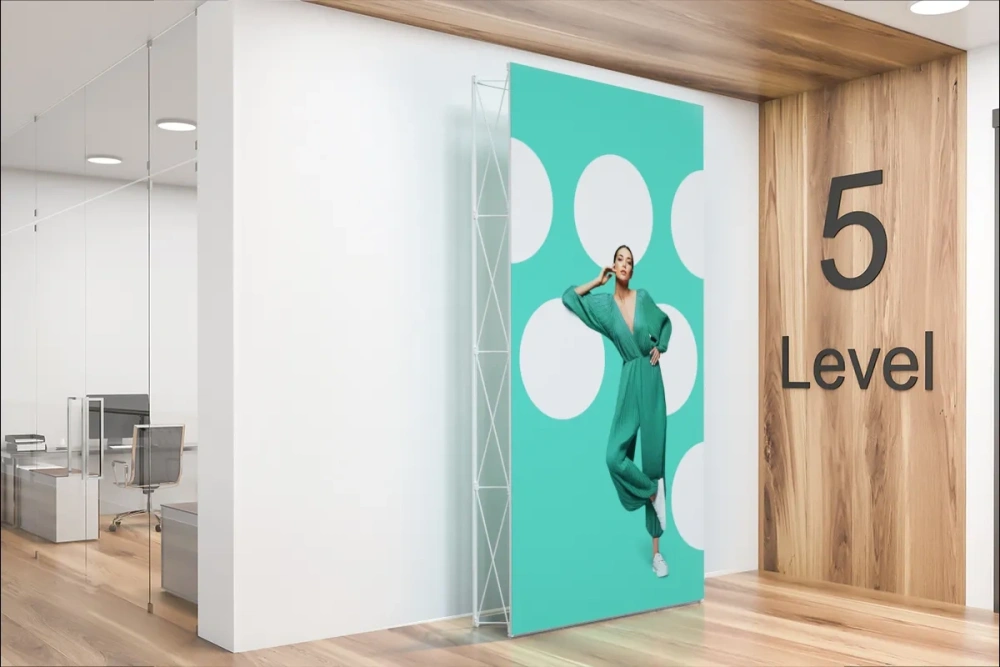 Stand parapluie moderne installé à l'entrée d'un bureau au niveau 5, avec visuel textile tendu sur structure pliante.