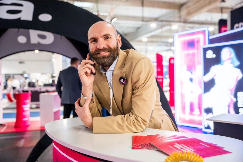 Asesor de adsystem en feria promocional, presentando soluciones personalizadas para stands.