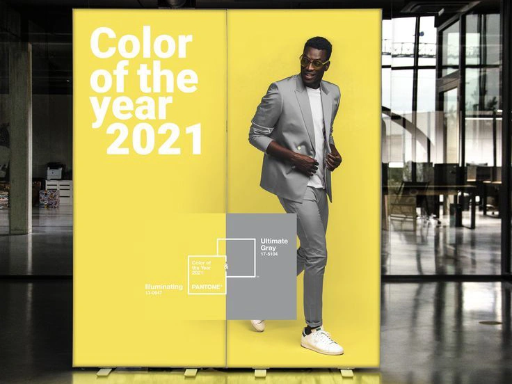 Kaseton z grafiką promującą kolory roku 2021 Pantone: Illuminating i Ultimate Gray, tło w żółtym odcieniu, postać w szarym garniturze, duży napis „Color of the year 2021”.