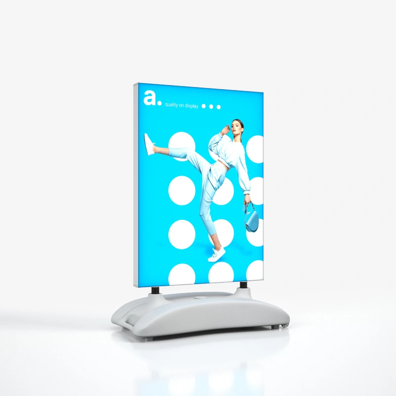 Dwustronny potykacz zewnetrzny z podswietleniem LED, osadzony na mobilnej podstawie, z grafika i logo na jasnoniebieskim tle.