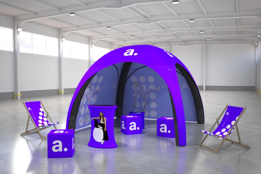 Namiot reklamowy z leżakami i trybunką w hali eventowej.