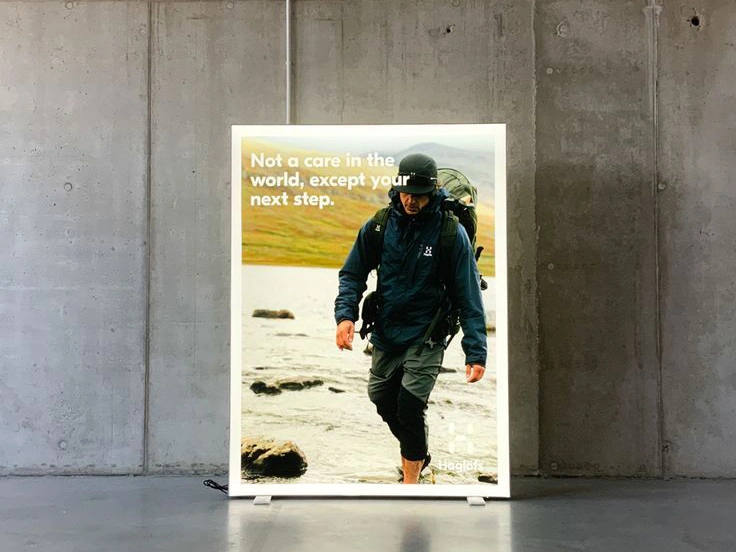 Kaseton z podświetlaną grafiką outdoorową z postacią w odzieży trekkingowej na tle górskiego krajobrazu.