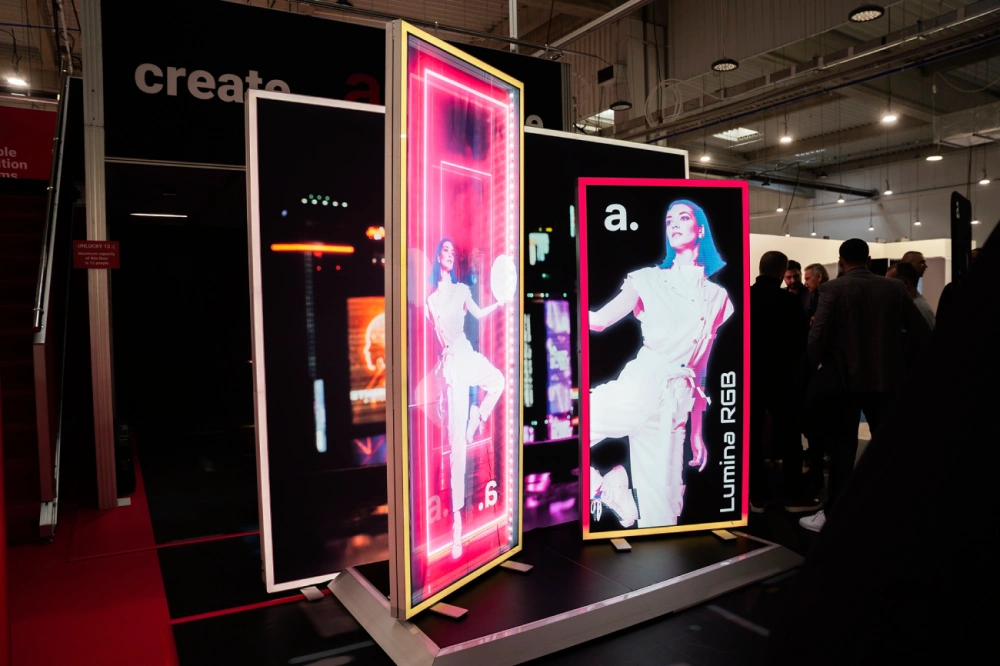 Displays publicitarios retroiluminados RGB en un stand de feria, diseñados para atraer la atención con efectos visuales impactantes.