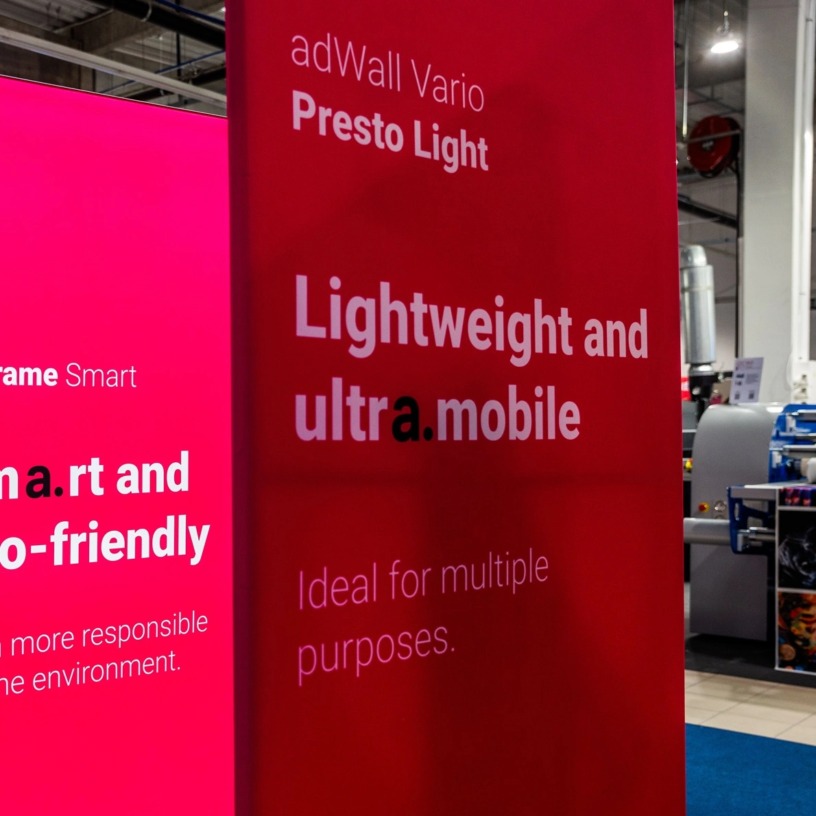 Zbliżenie na ściankę reklamową adWall Vario Presto Light z opisem jej lekkości i mobilności na tle stoiska targowego.