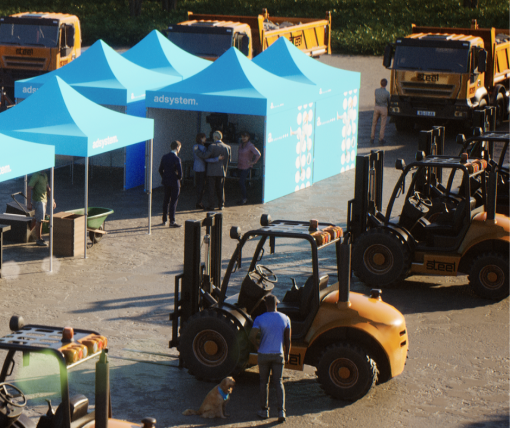 Namioty reklamowe adsystem na targach branżowych, ustawione obok maszyn rolniczych i budowlanych, z uczestnikami rozmawiającymi przy stoisku.