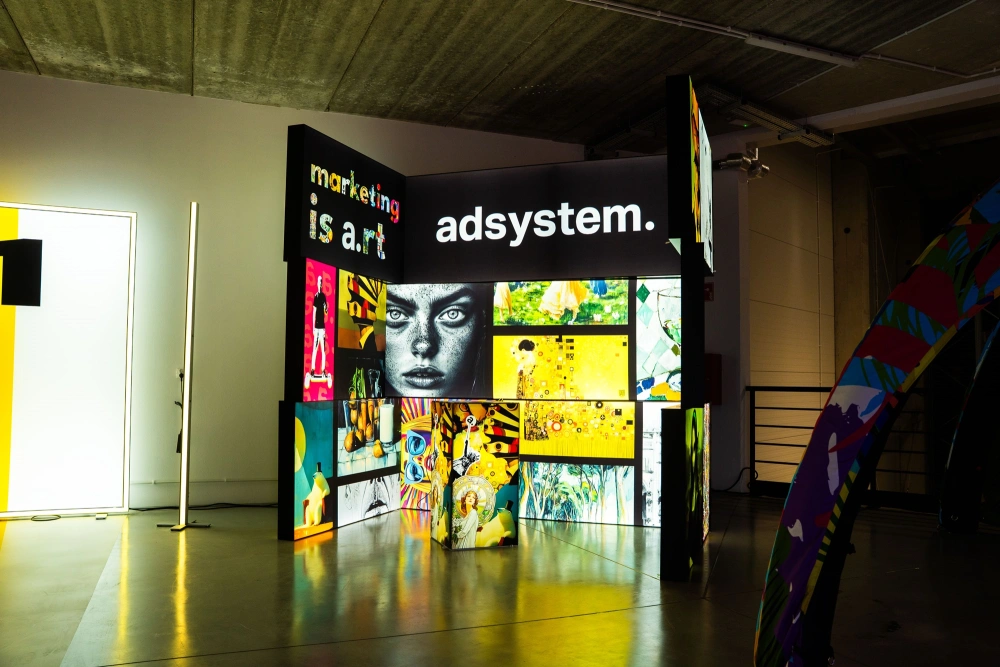 Podświetlane stoisko adsystem z artystycznymi grafikami i hasłem „marketing is art”, prezentujące modułowe systemy ekspozycyjne.
