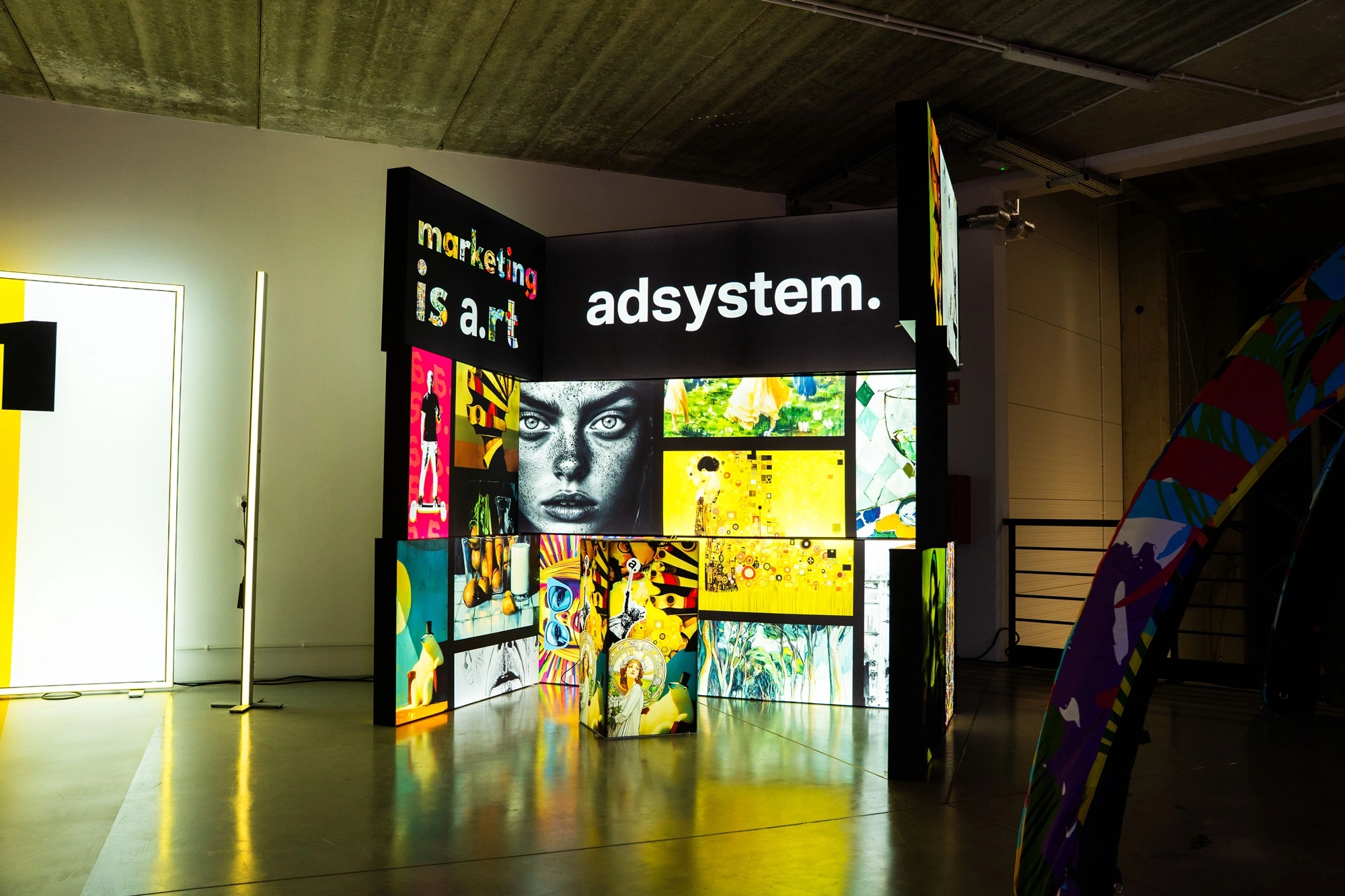 Podświetlane stoisko adsystem z artystycznymi grafikami i hasłem „marketing is art”, prezentujące modułowe systemy ekspozycyjne.