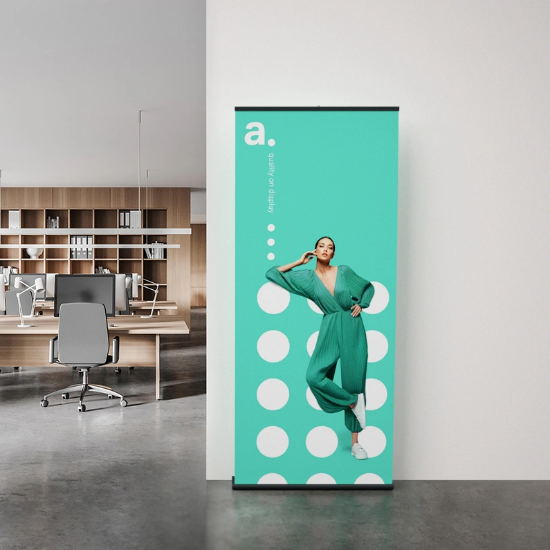 Roll-up ustawiony w nowoczesnym biurze – prezentuje nadruk promocyjny na tle w kolorze miętowym z graficznymi kropkami.