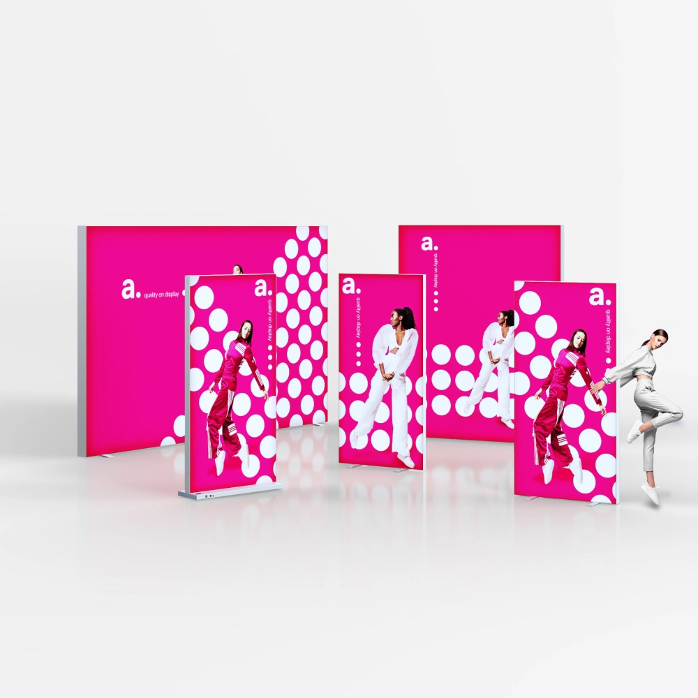 Zestaw wolnostojących kasetonów reklamowych z grafiką na różowym tle z białymi kropkami.