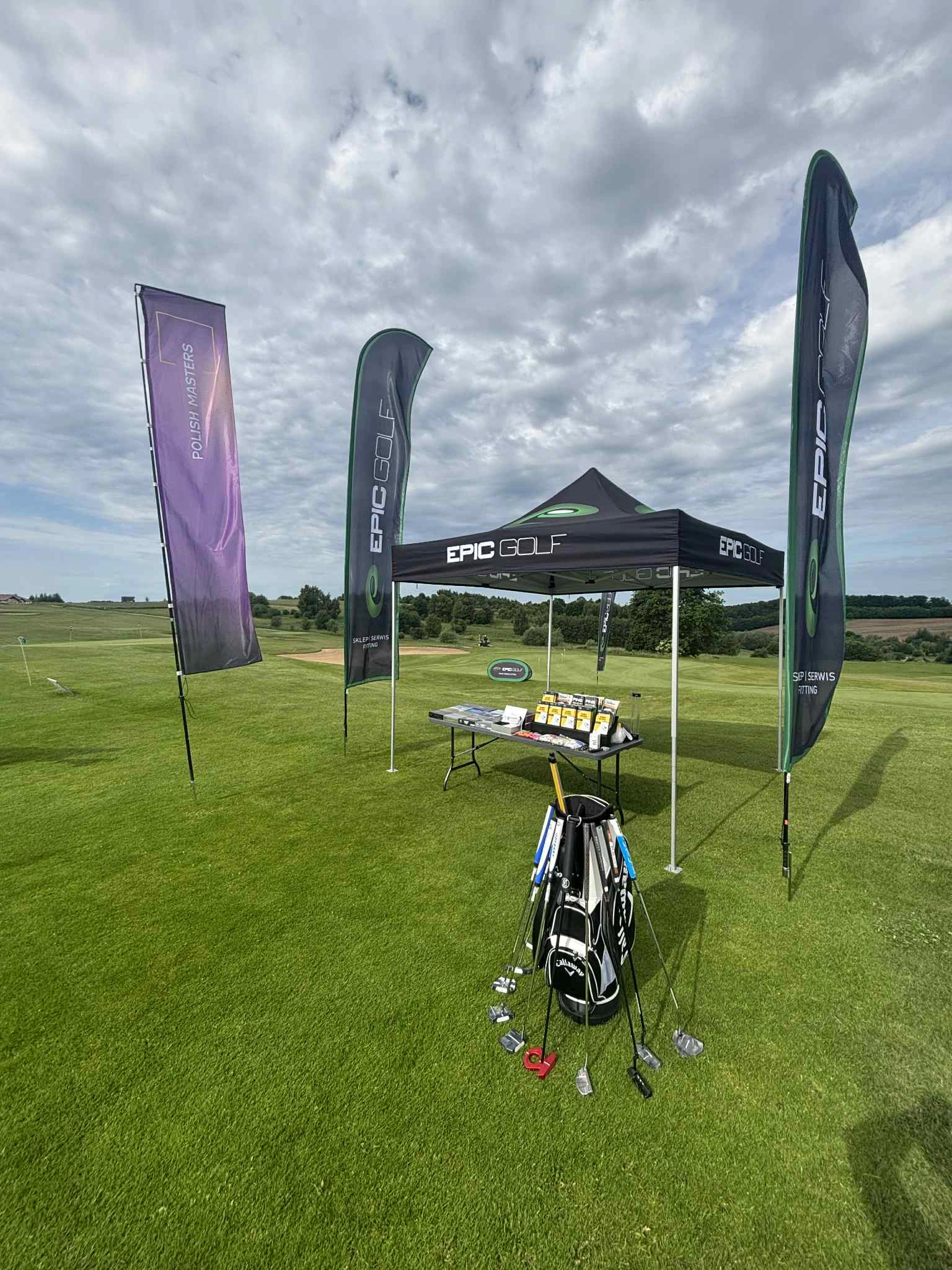 Namiot reklamowy i flagi ustawione na polu golfowym