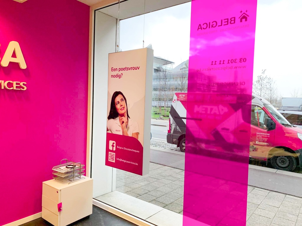 Nowoczesna ścianka reklamowa w odcieniach różu na tle minimalistycznego wnętrza sklepu