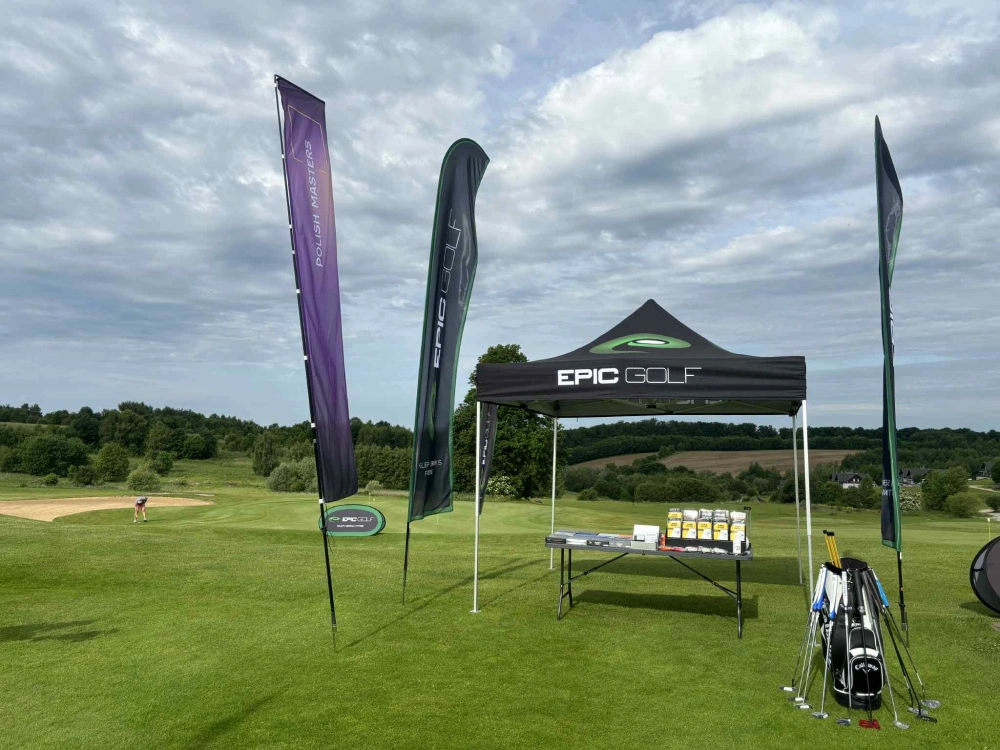 Namiot reklamowy i flagi ustawione na polu golfowym
