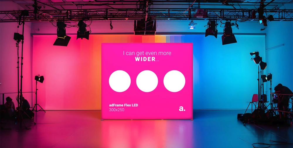 Podświetlany kaseton adFrame Flex LED na tle studia nagraniowego w oświetleniu różowo-niebieskim