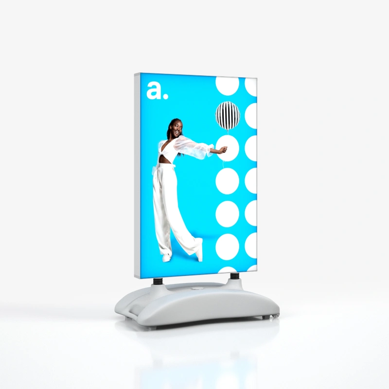 Dwustronny potykacz zewnetrzny LED z wymienna grafika, wyposazony w stabilna podstawe i przeznaczony do ekspozycji zewnetrznej lub w strefie wejsciowej.